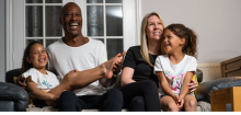 Family smiling and laughing on sofa