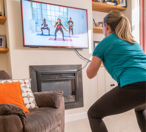 Lady exercising to exercise programme on her tv