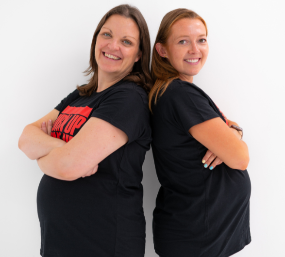 Two pregnant women standing back to back